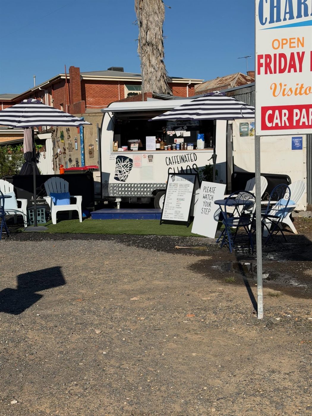 Caffeinated Chaos coffee van with striped umbrellas, 50 metres from the park