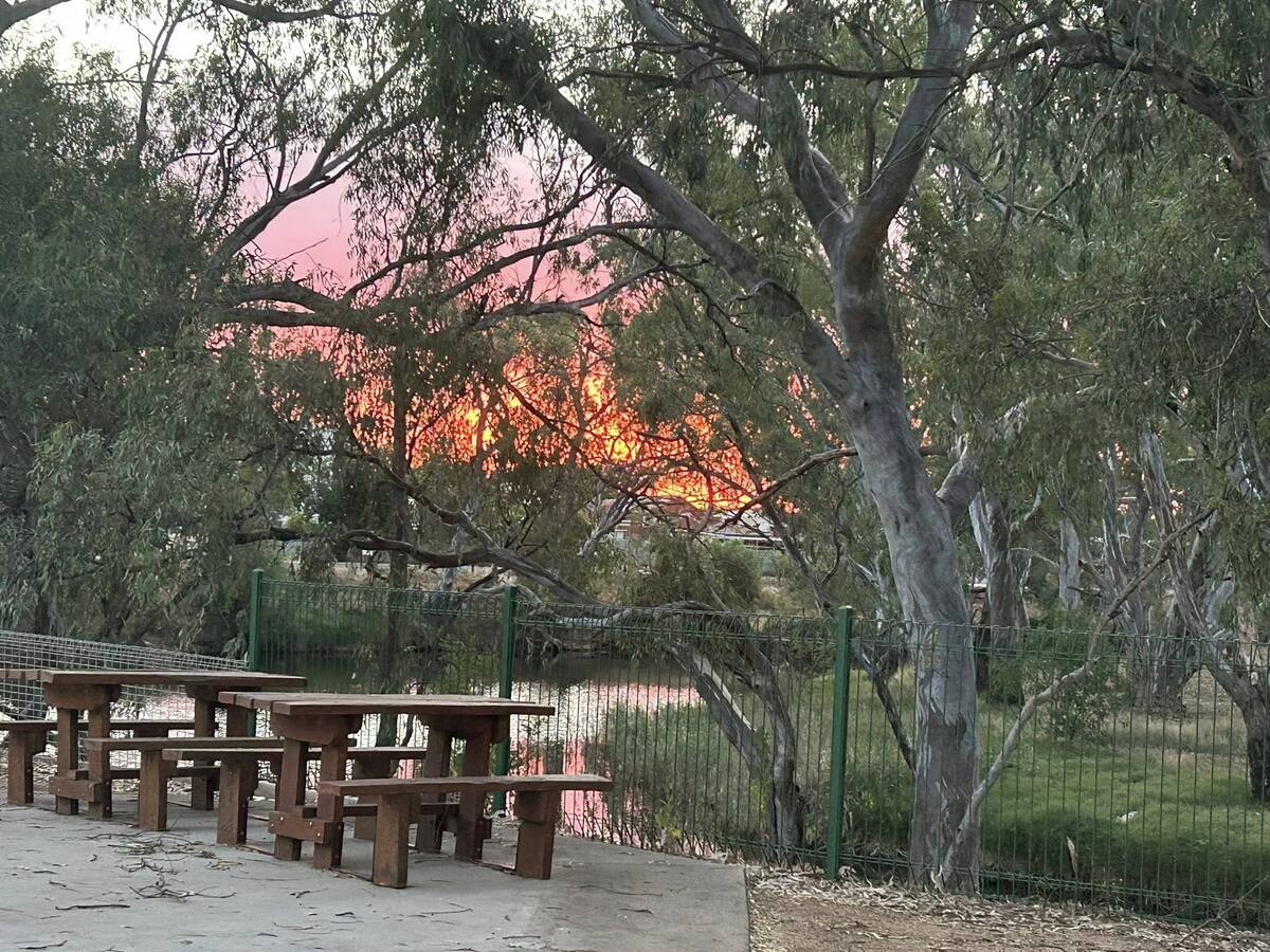 Picnic tables by the river at dusk